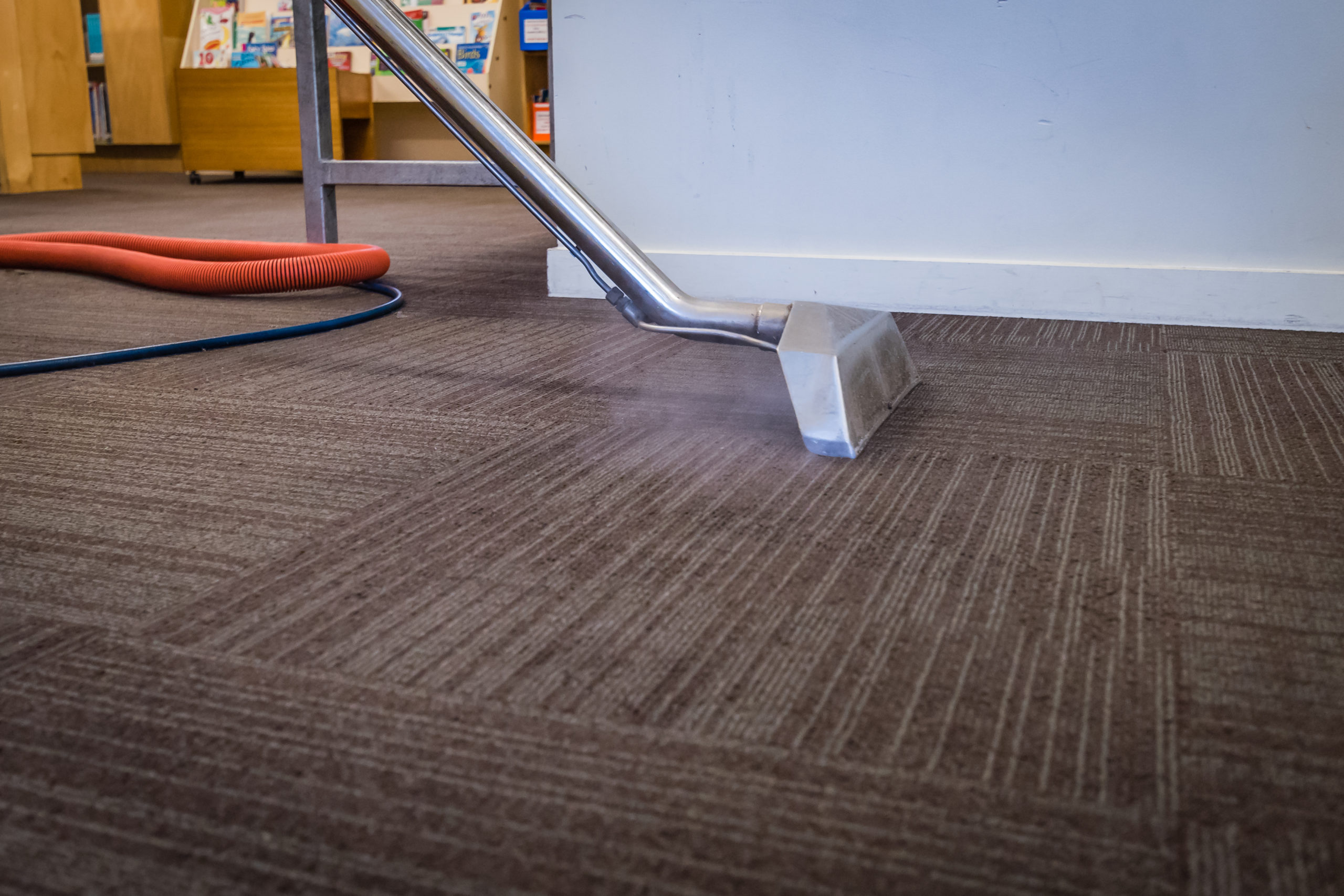 A vacuum is on the floor of a library